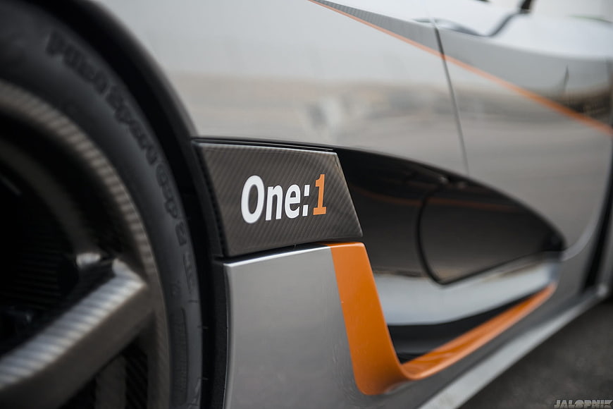 Close-up of McLaren One:1 side detail with carbon fiber and orange accents