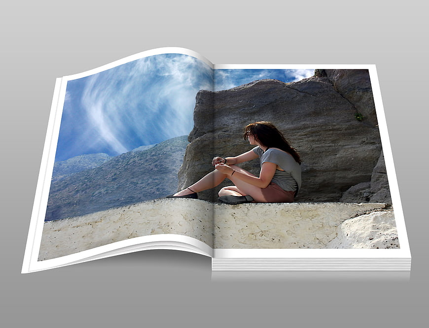 Open Photobook Mockup Featuring Woman Sitting On Rocky Cliff