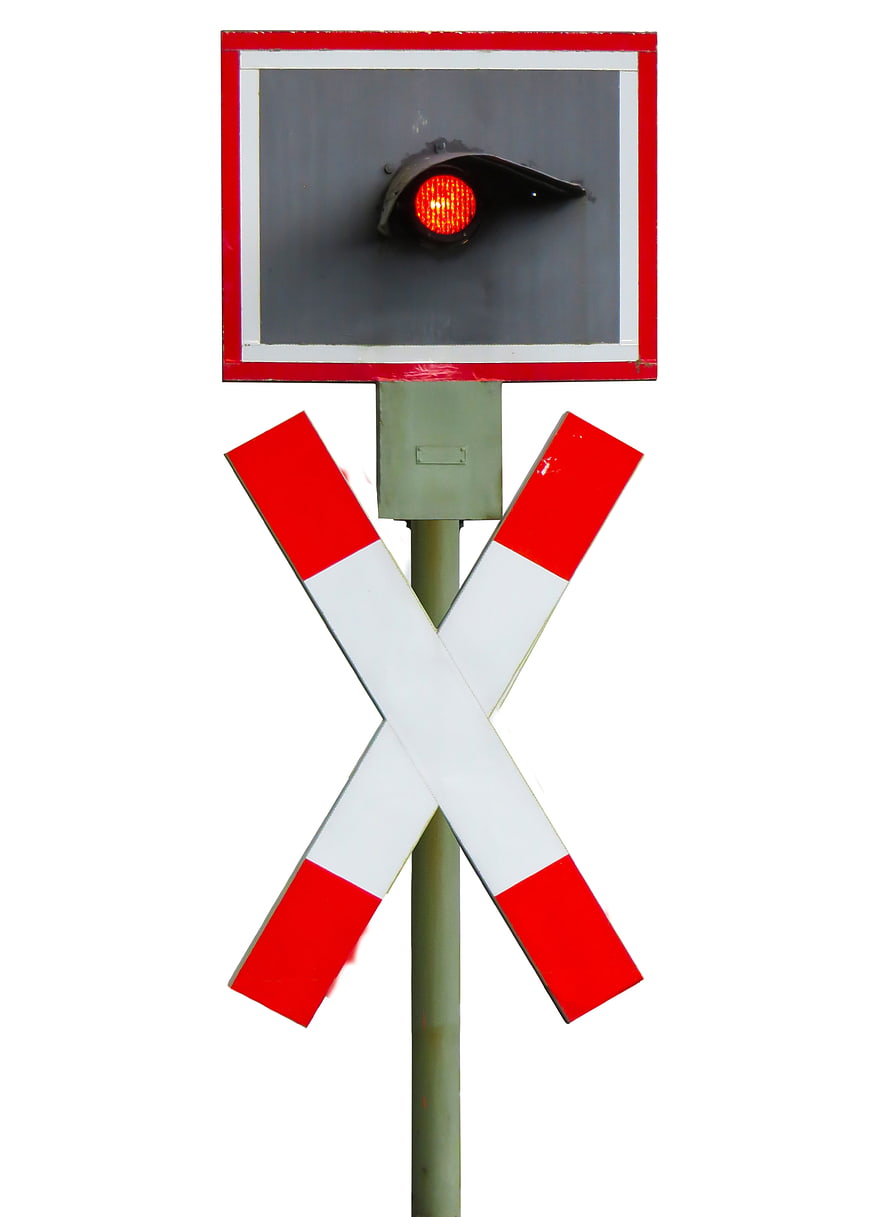 Railroad crossing signal with red light and crossbuck sign