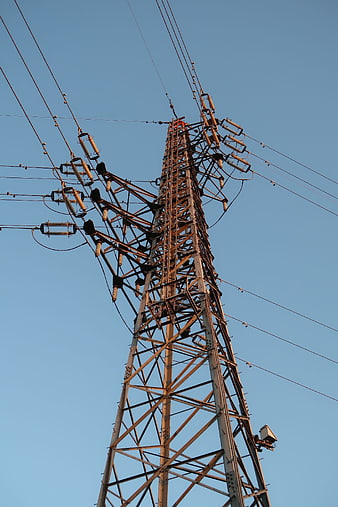 Low angle view of high voltage electricity pylon against blue sky