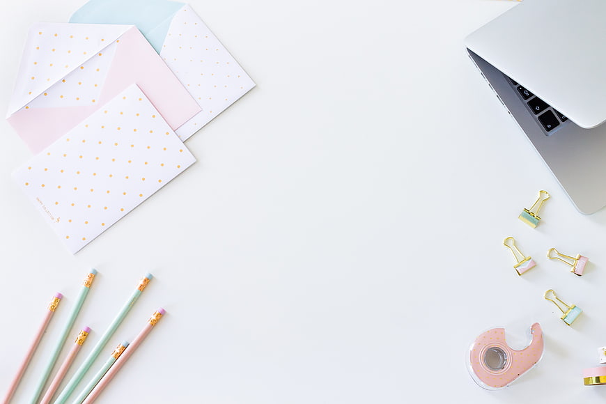 Minimalist pastel workspace flat lay with laptop and stationery