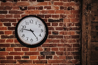 Classic Round Clock on Red Brick Wall