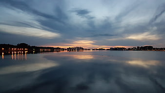 Serene Lake Sunset with City Skyline Reflection