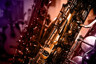 Close-up of golden saxophone keys with purple background