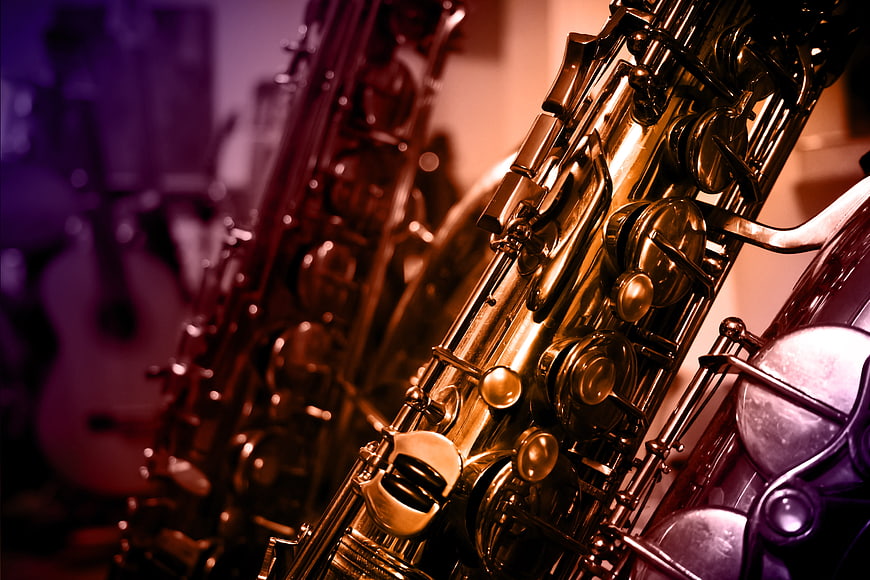 Close-up of golden saxophone keys with purple background