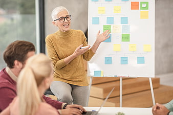 Senior woman presenting business strategy with sticky notes