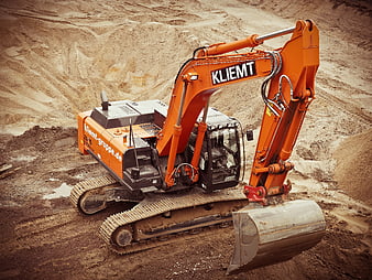 Orange excavator on construction site with dirt background