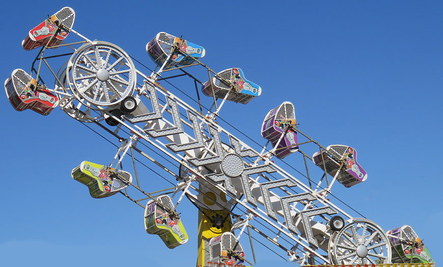 Colorful carnival swing ride against blue sky