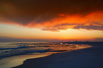 Dramatic Orange Sunset Over Ocean Beach With Silhouettes