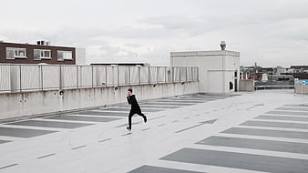 Man running on empty rooftop parking lot