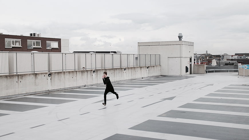 Man running on empty rooftop parking lot