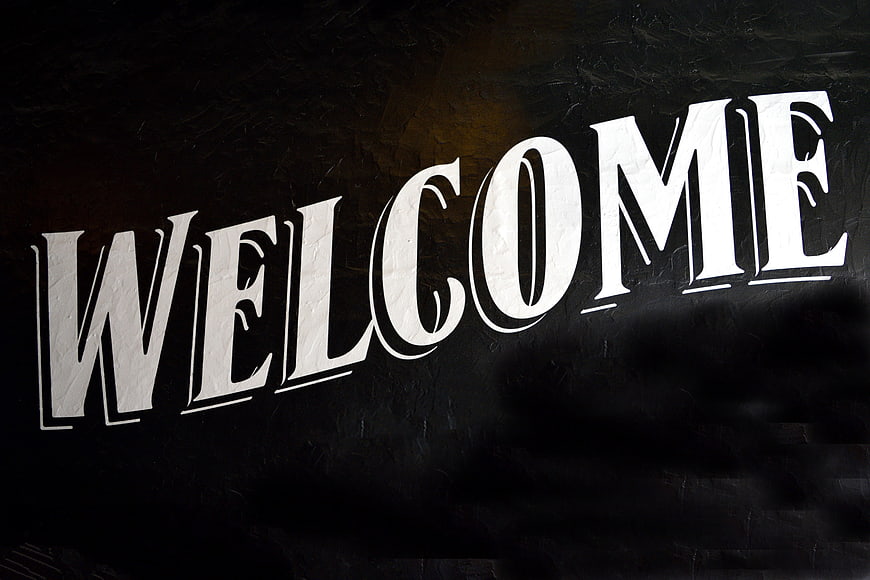 White Welcome Text on Dark Textured Background