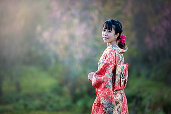 Woman in Red Kimono Smiling in Nature