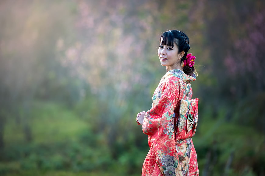 Woman in Red Kimono Smiling in Nature