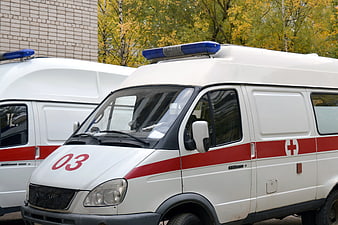White Ambulance Van With Red Cross Marking And Blue Light Bar