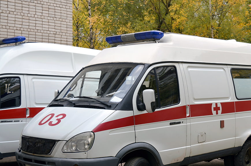 White Ambulance Van With Red Cross Marking And Blue Light Bar