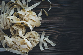 Fresh Tagliatelle Pasta on Dark Wood Background