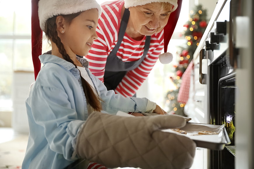 Grandmother and granddaughter baking Christmas cookies in kitchen