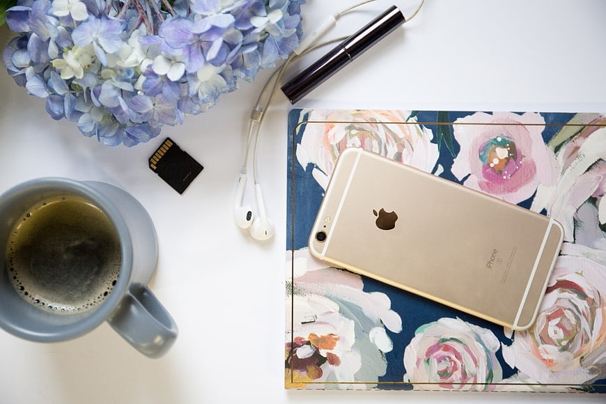 Flat Lay Workspace with Coffee, Smartphone, and Flowers