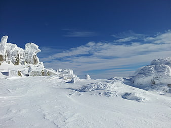 Snow-Covered Mountain Landscape With Deep Blue Sky And Winter Clouds
