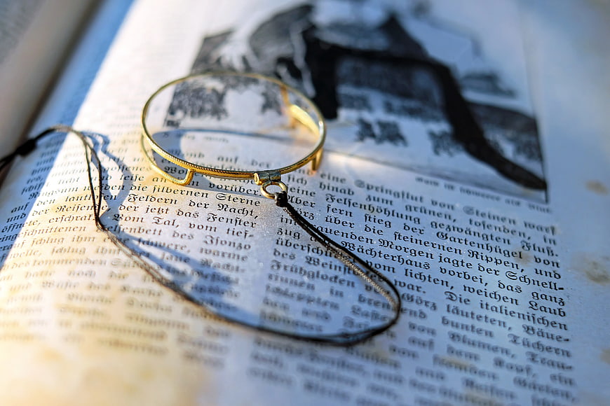 Vintage Magnifying Glass on Old German Text Book Page