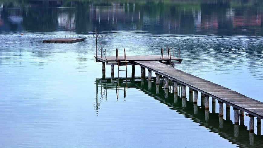 Wooden Dock Extending into Calm Blue Lake Water