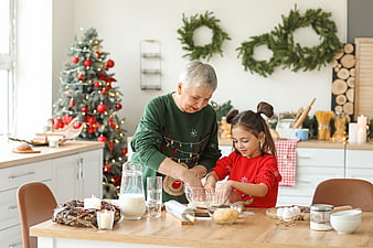 Grandmother and granddaughter baking Christmas cookies in kitchen