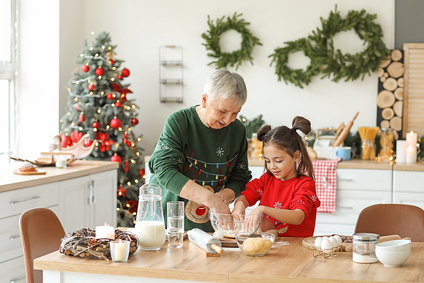 Grandmother and granddaughter baking Christmas cookies in kitchen