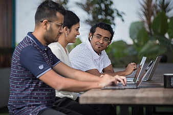Diverse Team Collaborating on Laptops Outdoors
