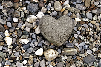 Heart-shaped stone on a bed of natural pebbles and rocks