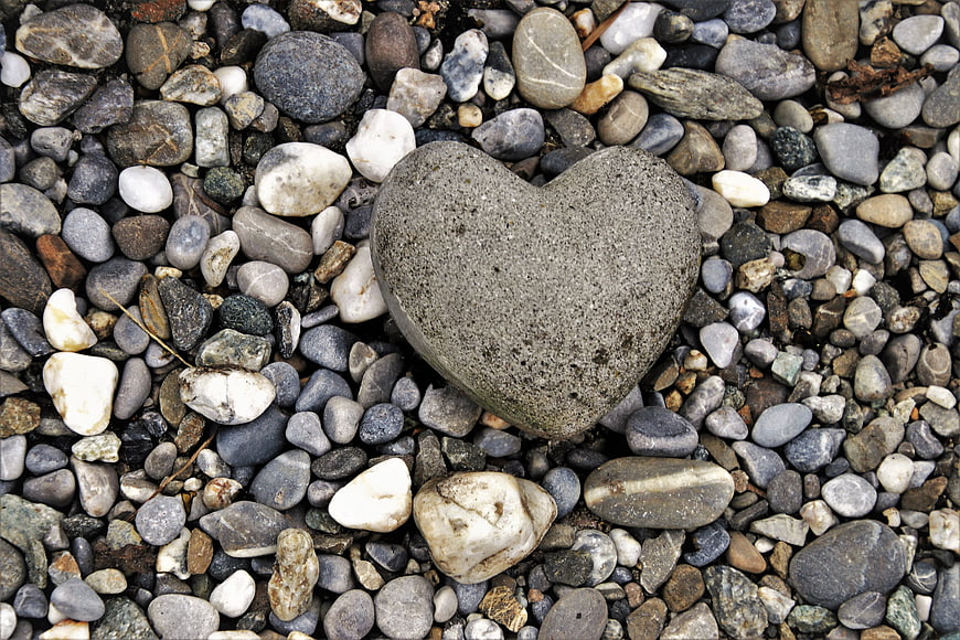 Heart-shaped stone on a bed of natural pebbles and rocks
