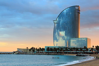 Hotel W Barcelona at sunset with beach and palm trees