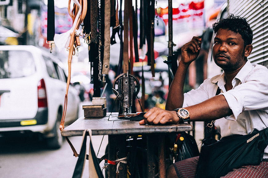 Street Vendor Repairing Belts at Outdoor Stall