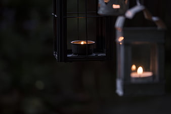 Close-up of lit tea light candles in hanging metal lanterns
