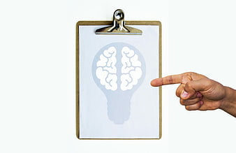 Hand pointing at brain icon on clipboard for idea concept