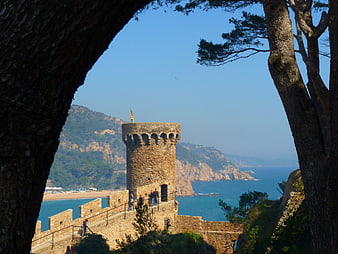 Historic Stone Watchtower Framed By Pine Trees Overlooking Mediterranean Sea