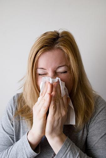 Woman Blowing Nose with Tissue for Flu and Cold Concept