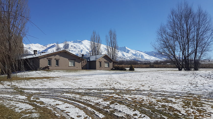 Modern house with snow-covered mountains in winter landscape