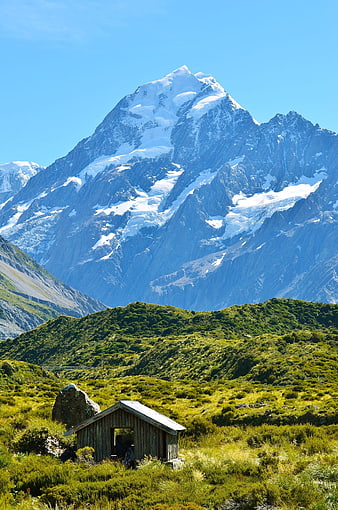 Snow-Capped Mountain Peak With Rustic Cabin In New Zealand