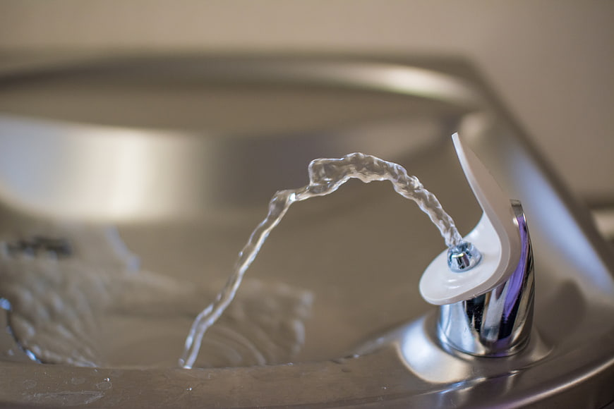 Close-up of a stainless steel drinking fountain with water flowing