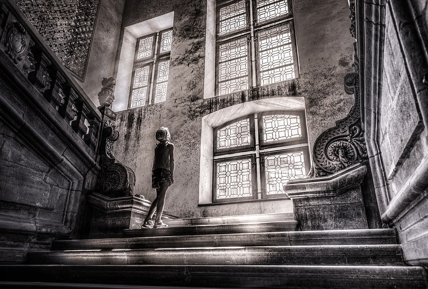 Girl standing on grand staircase in old building