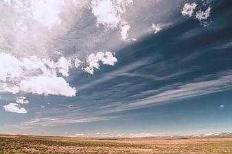 Vast Sky with White Clouds Over Golden Grassland