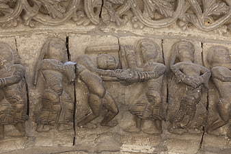 Ancient stone relief sculpture of figures in combat