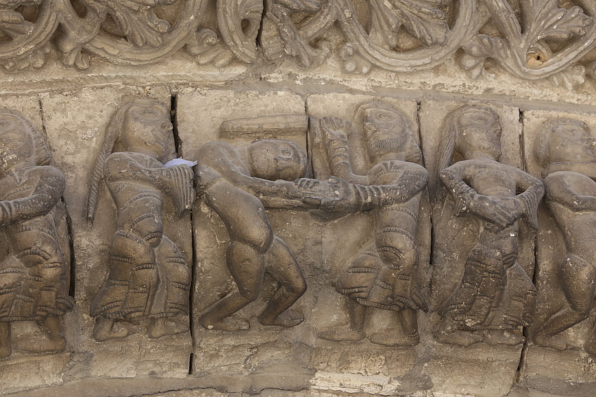 Ancient stone relief sculpture of figures in combat