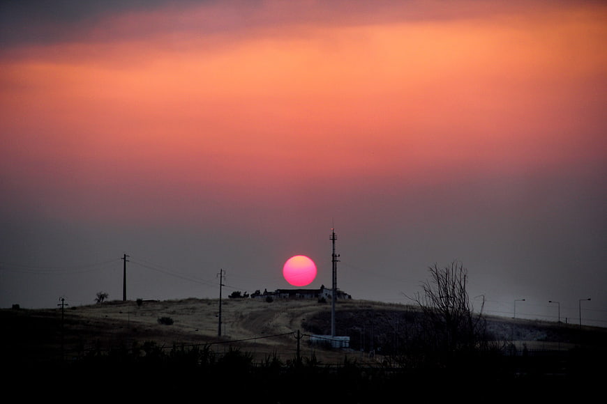 Vibrant pink sunset over rural Alentejo landscape with silhouetted hills