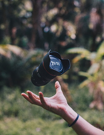 Camera Lens Floating Above Hand in Nature