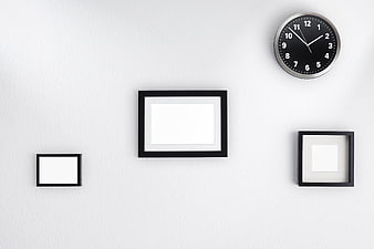 Minimalist White Wall with Black Picture Frames and Clock