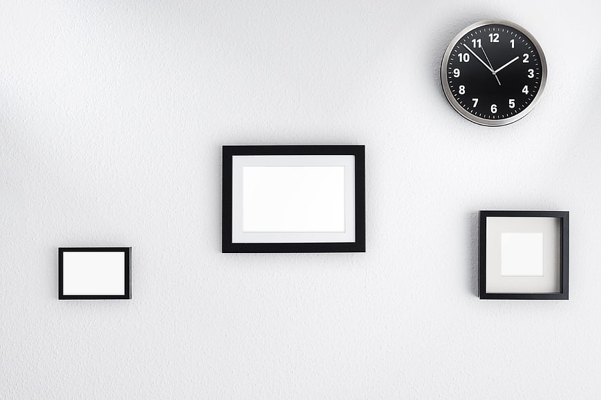 Minimalist White Wall with Black Picture Frames and Clock