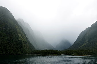 Misty Fjord Landscape with Steep Green Mountains and Calm Water
