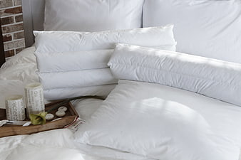 White Bedding With Pillows And Wooden Tray In Bedroom